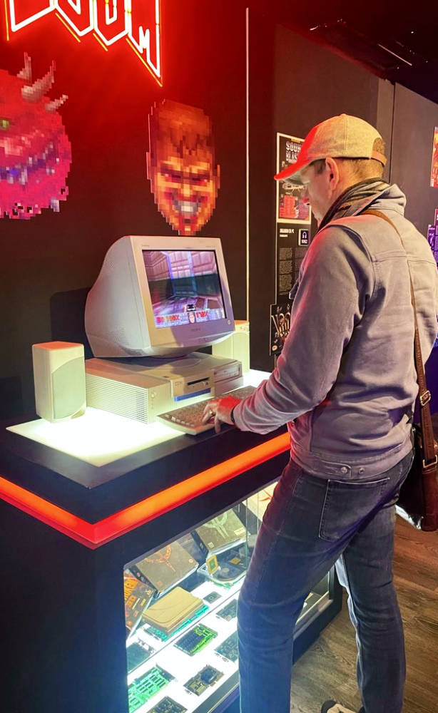 Steve from Caffeine Injection playing the classic game 'Doom' on a vintage PC at the OXO Video Game Museum in Malaga.